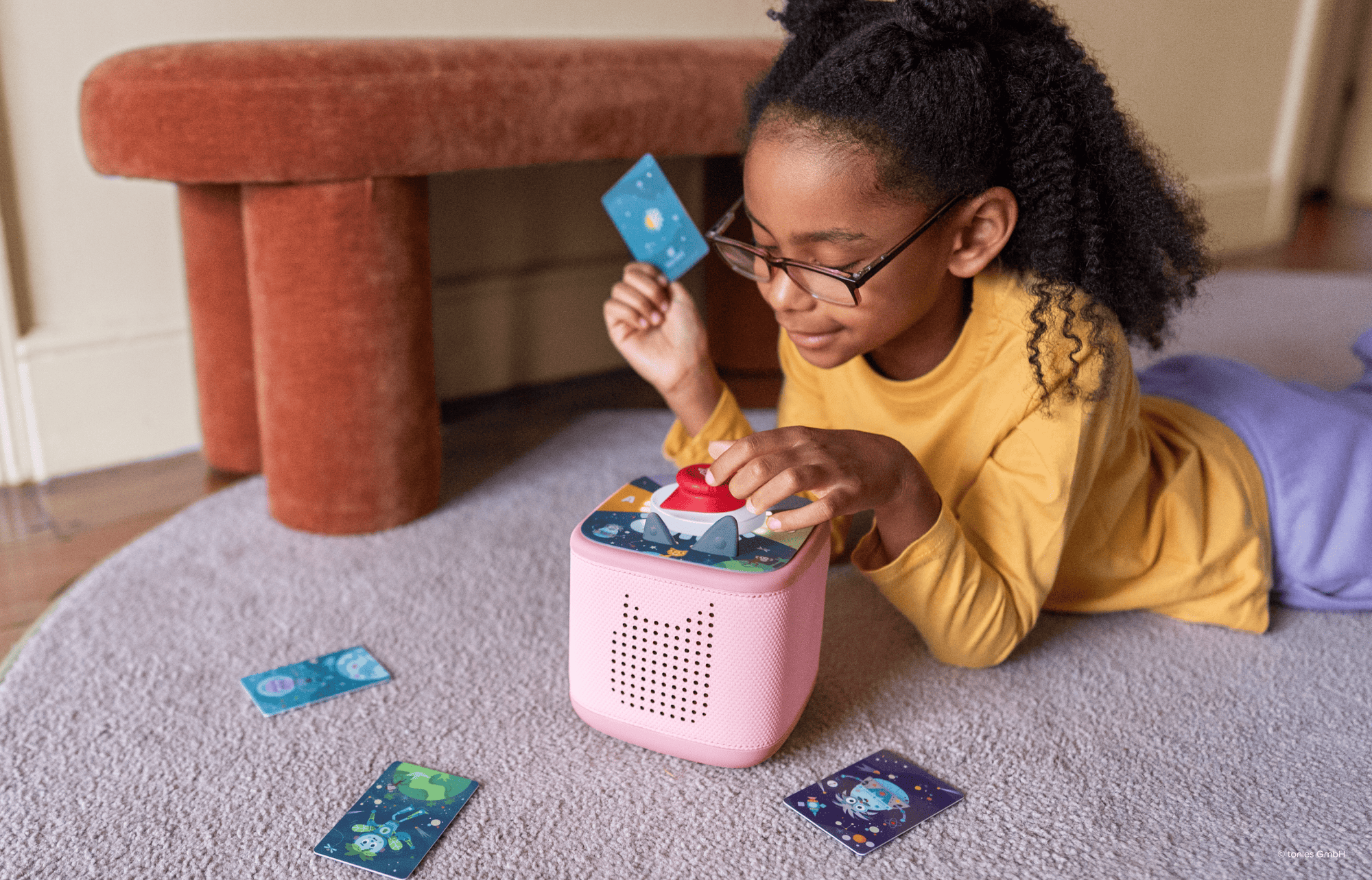 girl playing Tonieplay game with controller and pink Toniebox 2