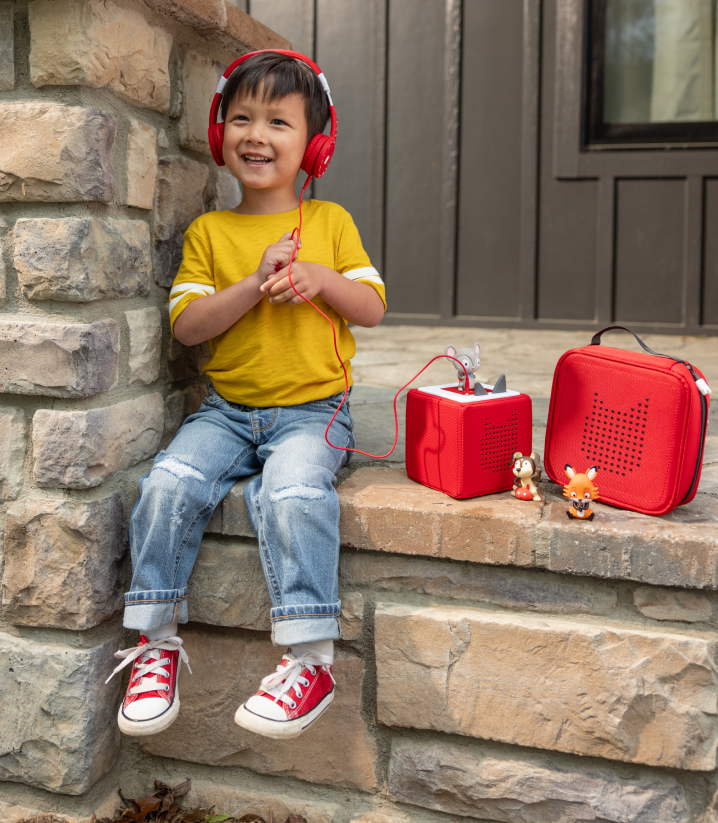 child listening to a Toniebox with headphones for engaging screen free fun.