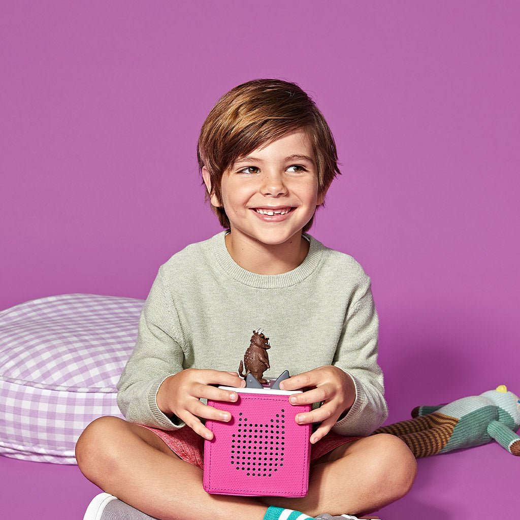 A young boy playing with the Gruffalo Tonie on a Toniebox