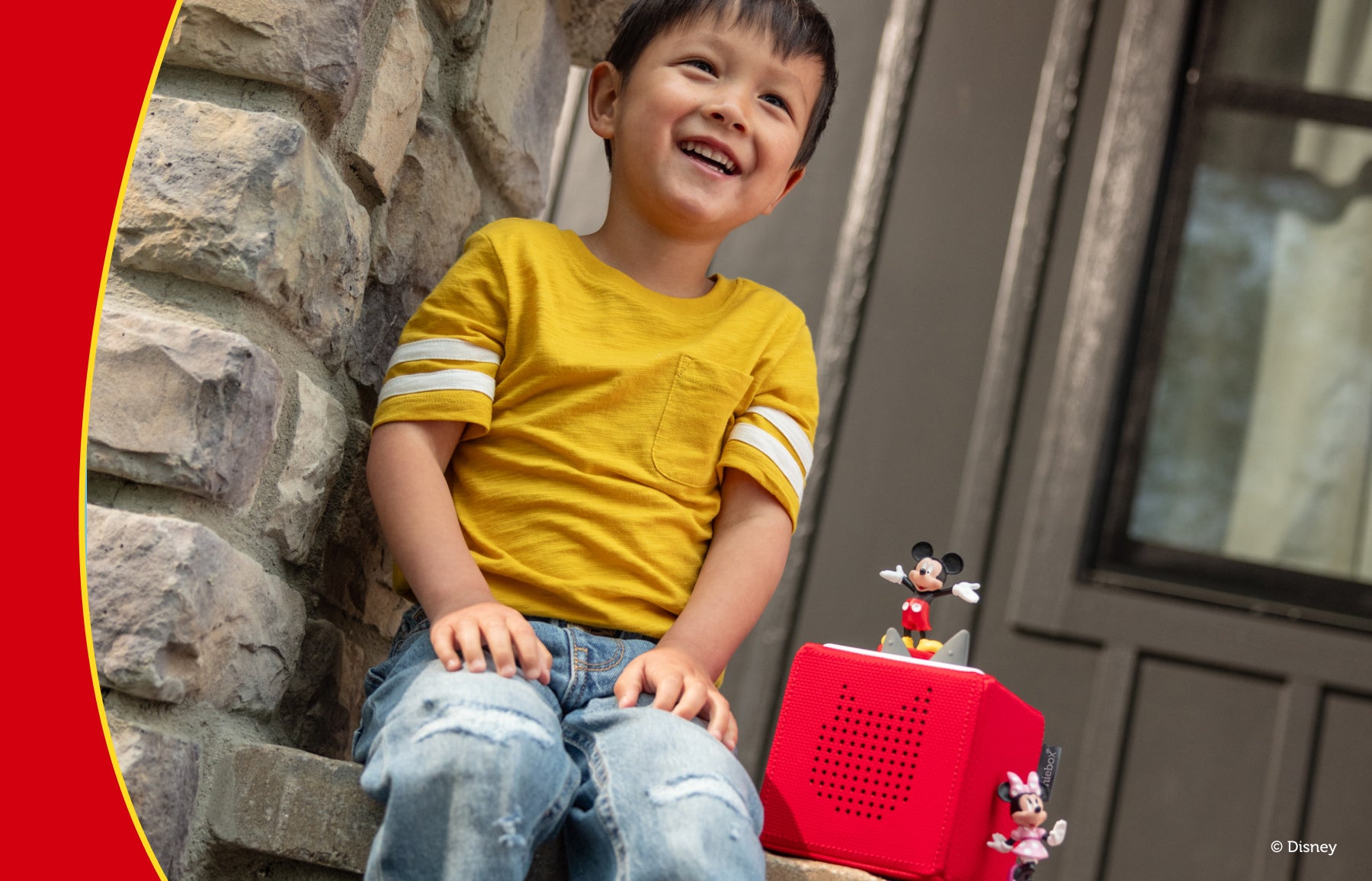 Child playing outside with mickey mouse tonie and a red toniebox