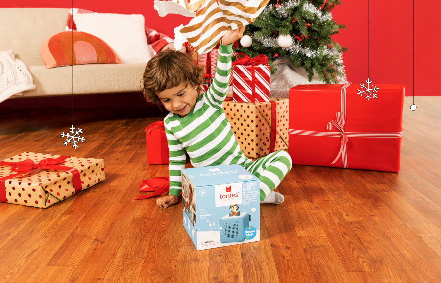 Child opening a Toniebox under the Christmas Tree