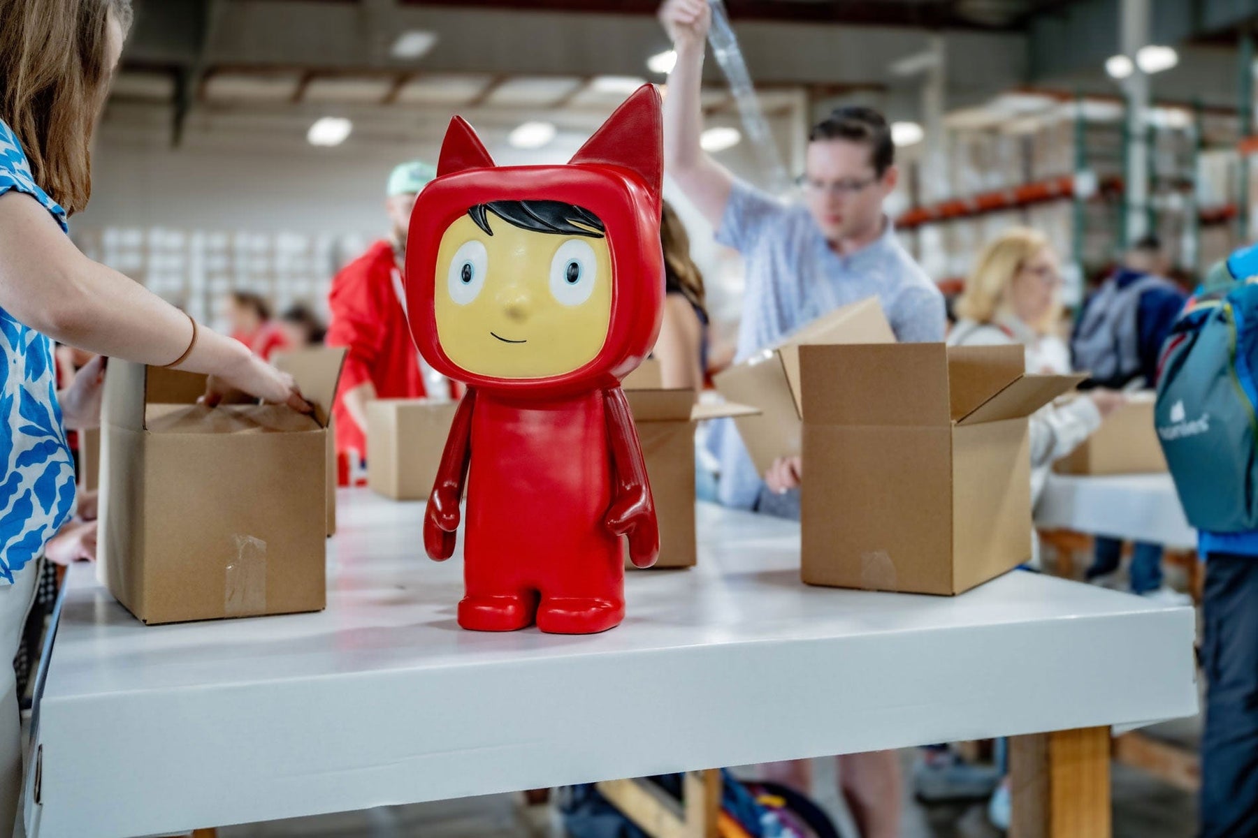tonies mascot helping employees pack boxes for charity initiatives
