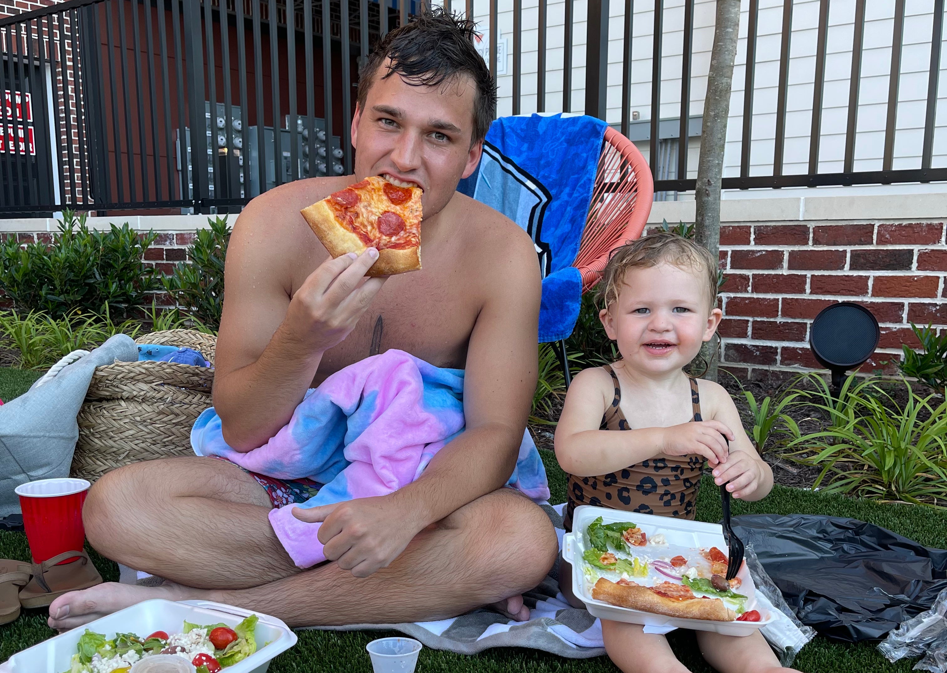 Man and young child eating pizza together