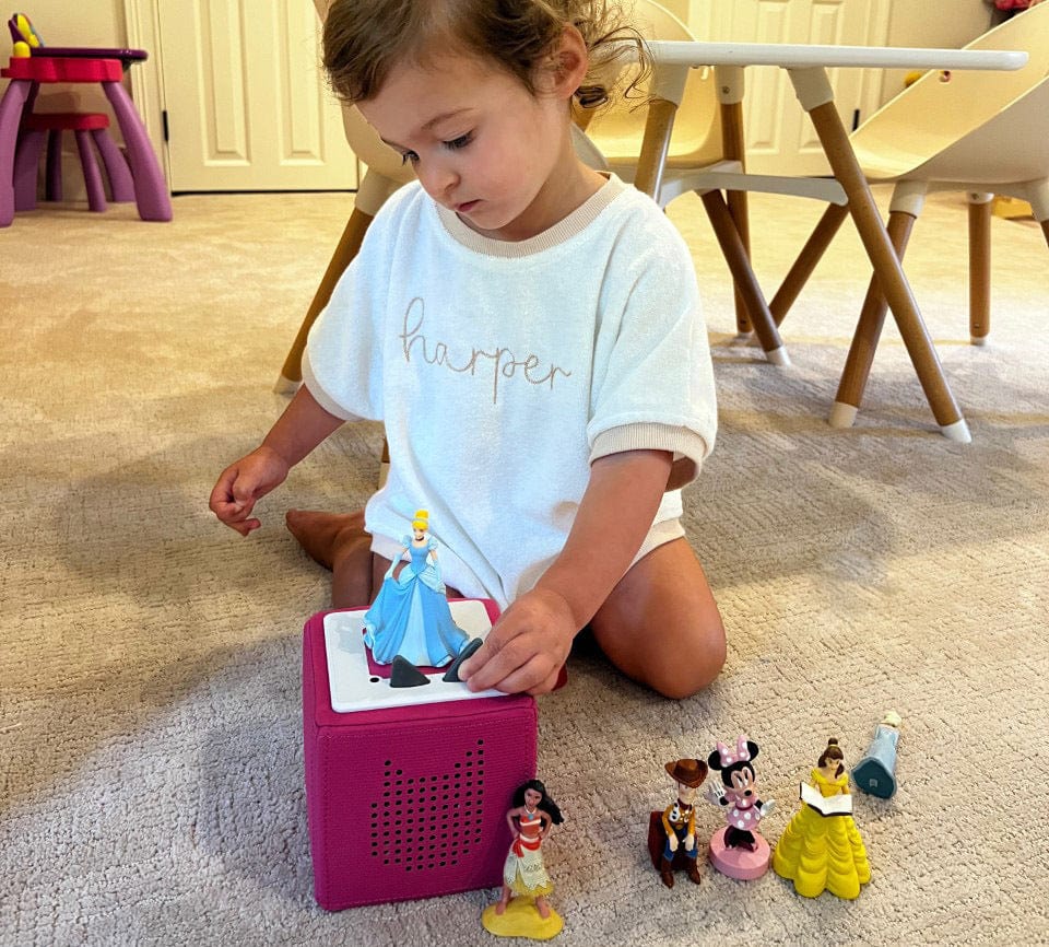 Child playing with Tonies on pink Toniebox