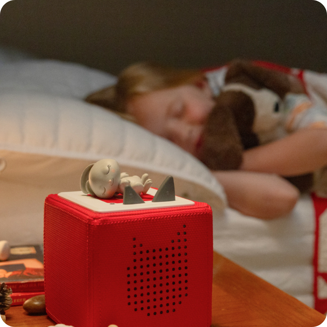 child sleeping near a red toniebox and sleepytime tonies