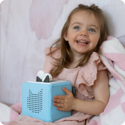 child playing with a sleepy sheep tonie and a blue toniebox