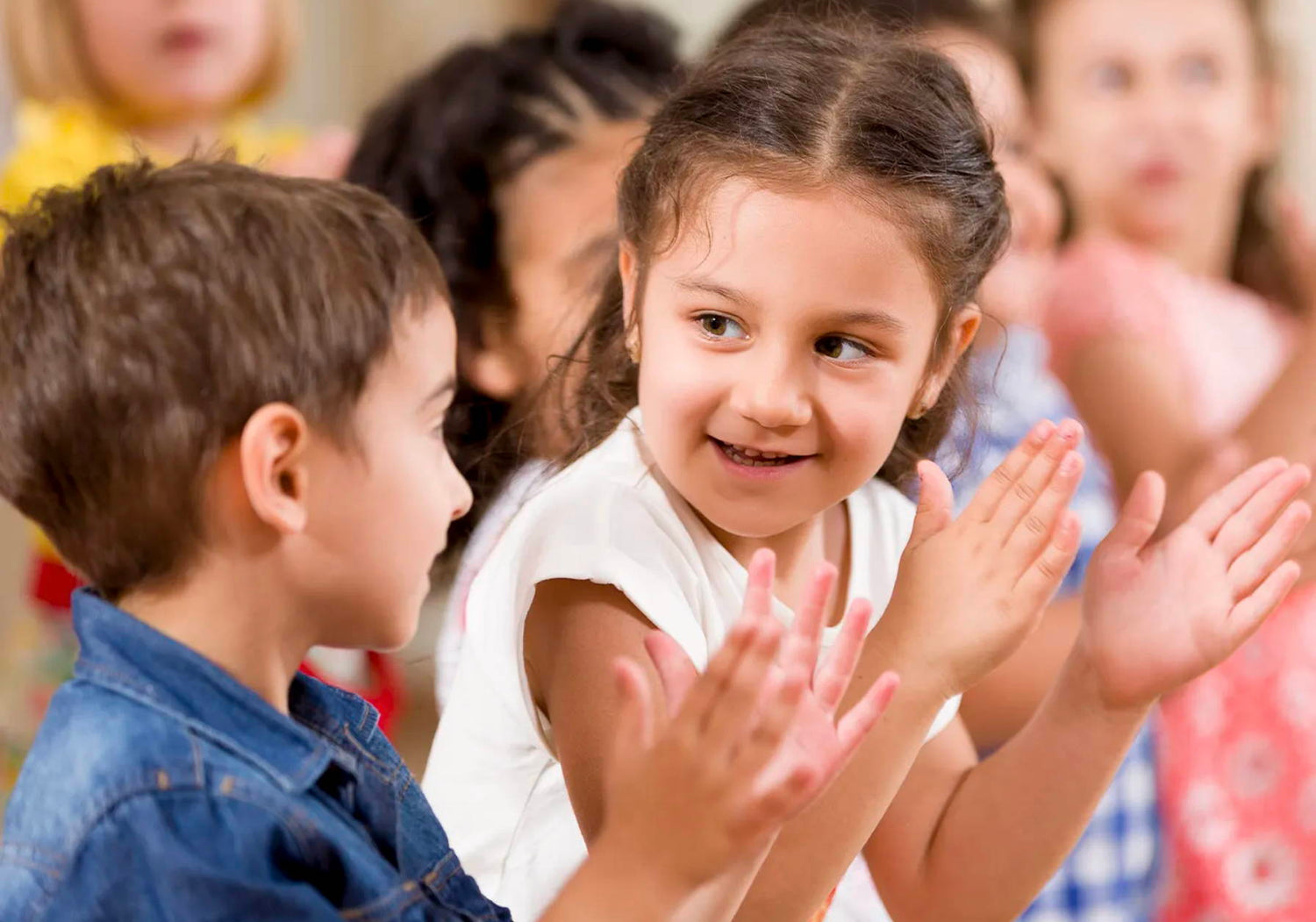 Children clapping in the audience of a performance
