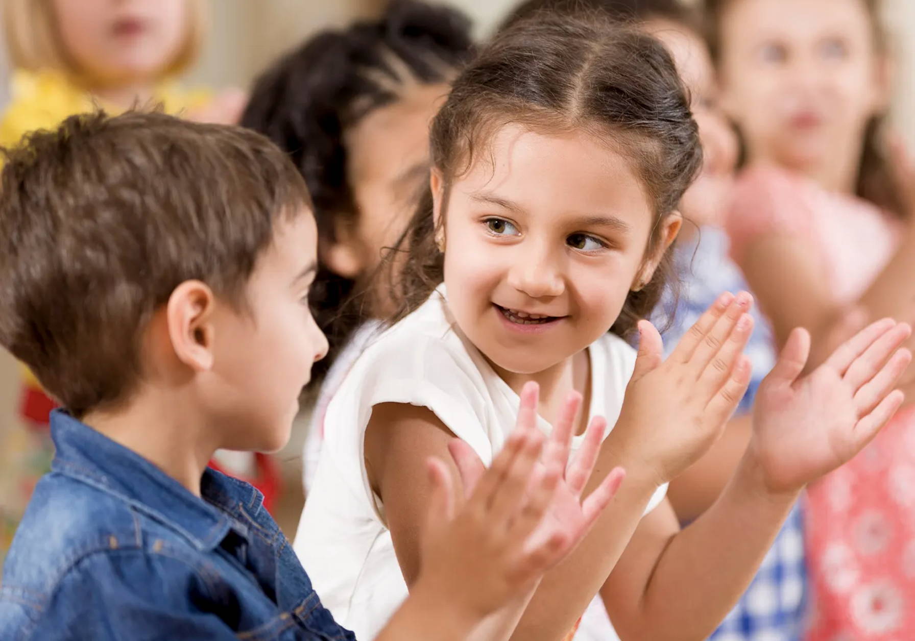 Children clapping in the audience of a performance