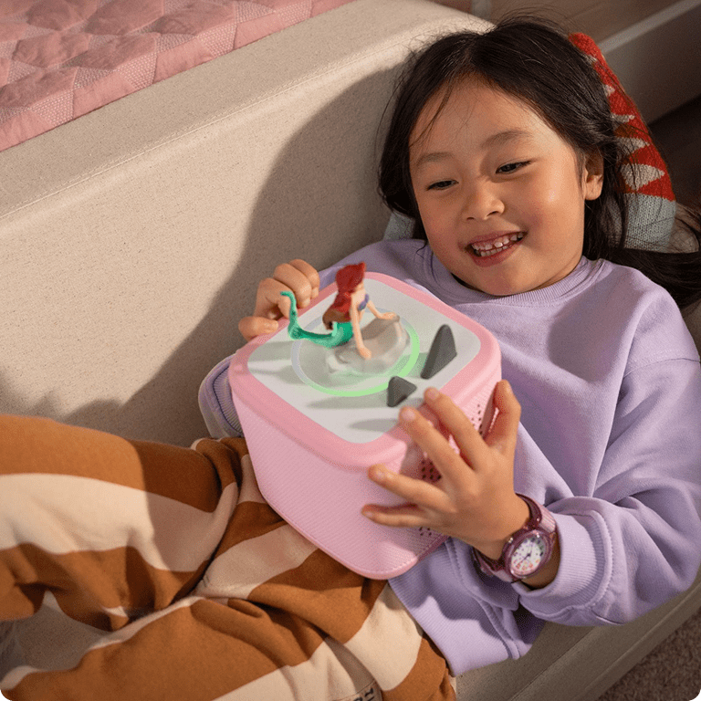 little girl listening to the Little Mermaid Tonie with a pink Toniebox 2