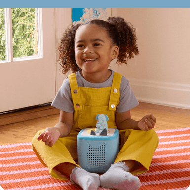 Child sitting and listening to Greta the Elephant Tonie on a blue Toniebox 2