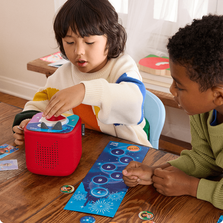 two children playing a Disney Tonieplay Game on a red Toniebox 2