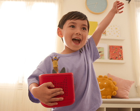 child listening to the Doggyland Tonie on a red Toniebox 2