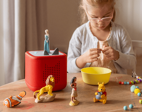child enjoying craft time while listening to Disney Tonies on a red Toniebox 2