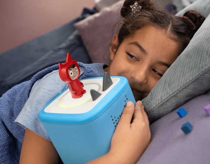 Girl listening to a creative Tonie on a blue Toniebox 2