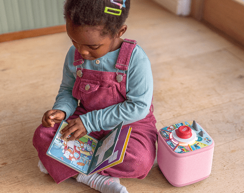 child playing a Tonieplay Game with controller and pink Toniebox 2