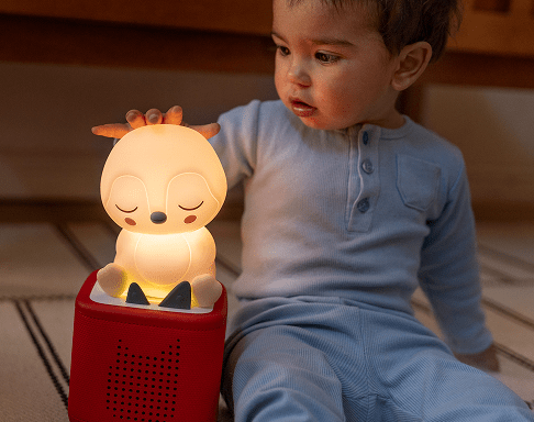 child looking at the Sleepy Penguin Night Light Tonie on a red Toniebox 2
