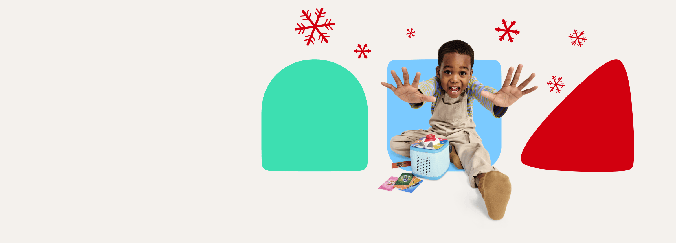 Child with blue Toniebox 2 and Tonieplay game with holiday snowflakes and shapes in the background